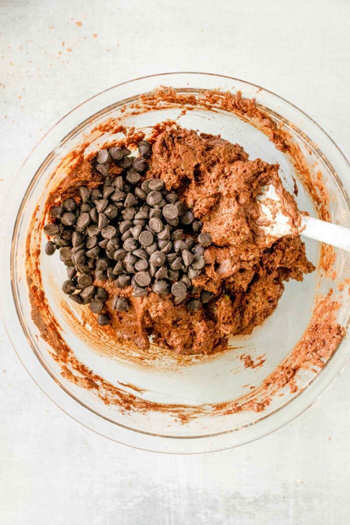 Chocolate chips added to chocolate batter in a mixing bowl.