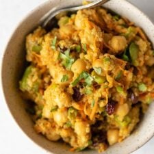 Overhead view of a curried salad with quinoa, chickpeas, carrot, scallions and cranberries.