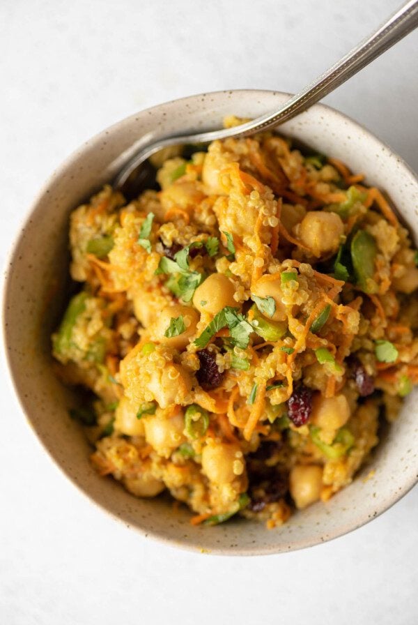 Overhead view of a curried salad with quinoa, chickpeas, carrot, scallions and cranberries.