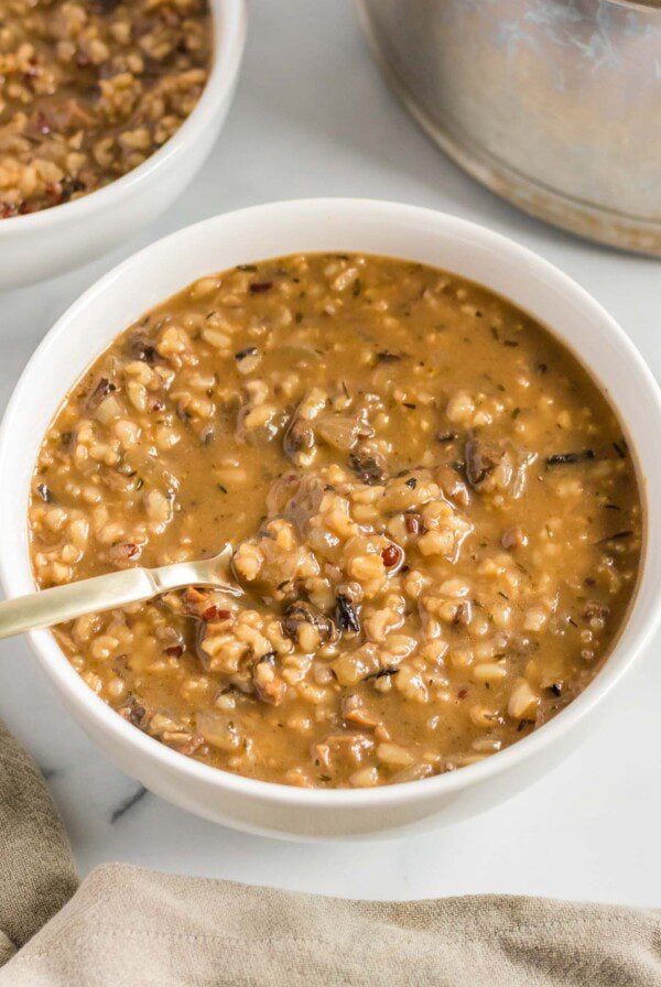 Bowl of mushroom wild rice soup with a spoon in it.