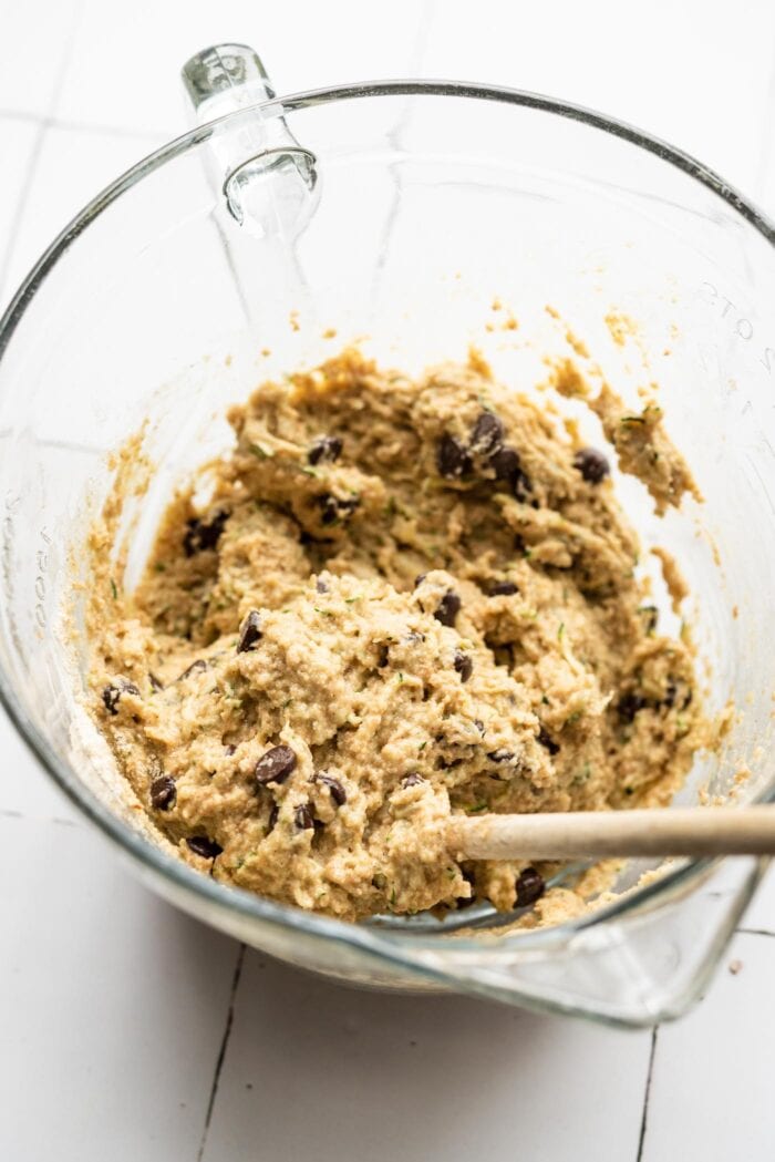 Chocolate chip zucchini muffin batter mixed in a glass mixing bowl.