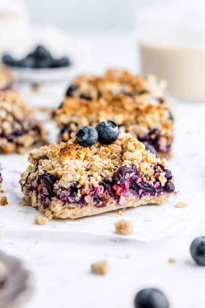 A blueberry crumble oat bar on a piece of parchment paper.