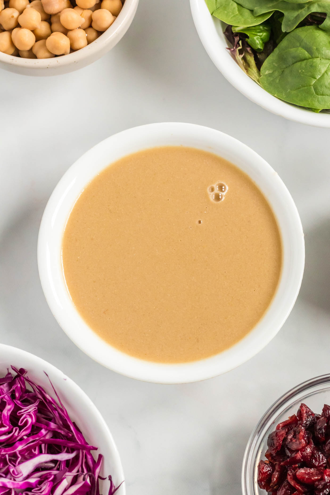 A bowl of creamy, smooth tahini, ready to be whisked into a dressing.