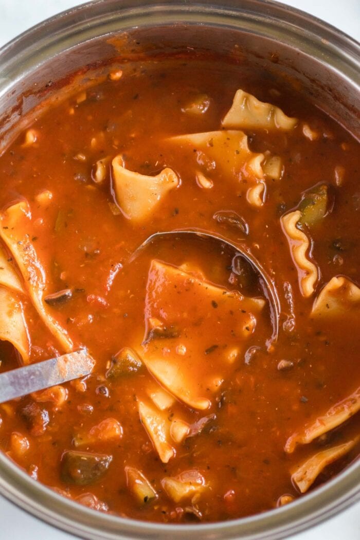 Ladle in a large pot of tomato lasagna soup.