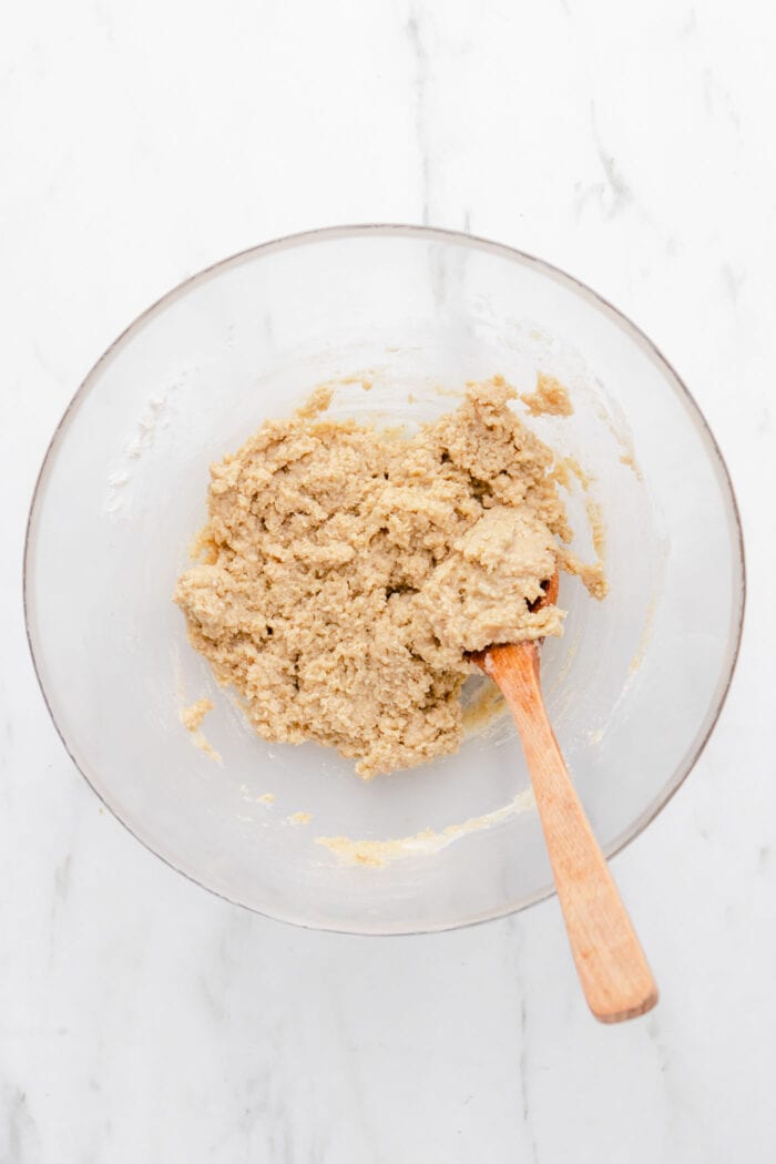 Raw pie crust batter in a mixing bowl with a wooden spoon.