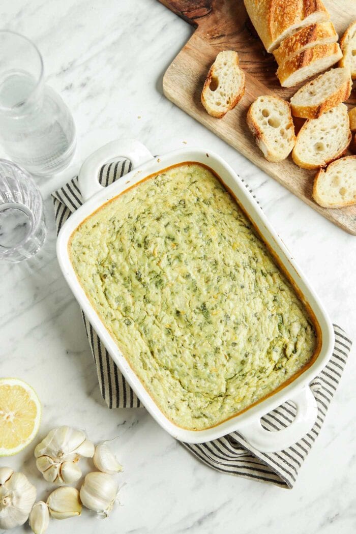 Cooked spinach artichoke dip in a baking dish.