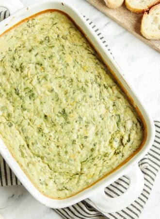 Overhead view of spinach artichoke dip in a baking pan.