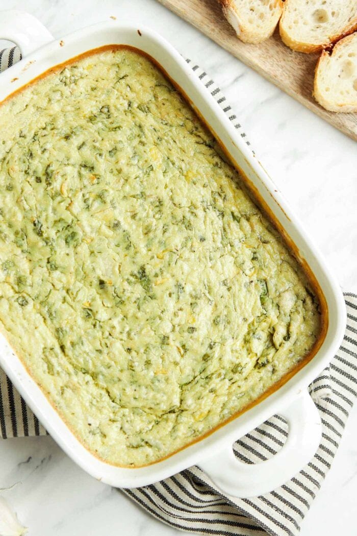 Overhead view of spinach artichoke dip in a baking pan.