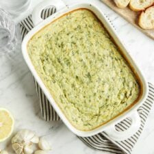 Cooked spinach artichoke dip in a baking dish.