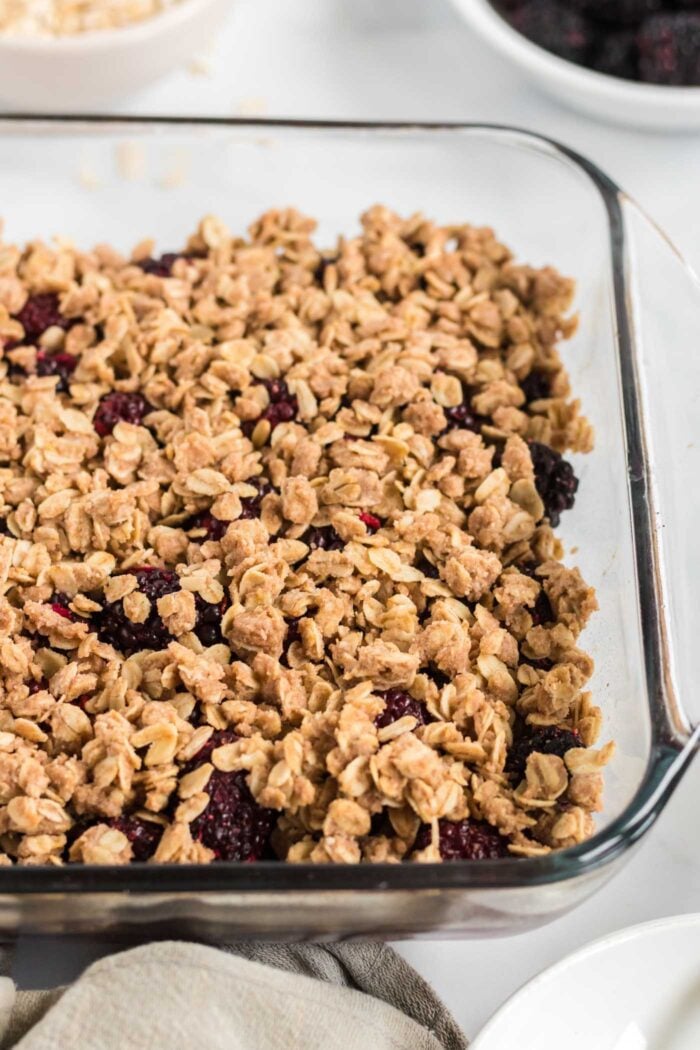 Close up of a baked blackberry crumble in a baking dish.