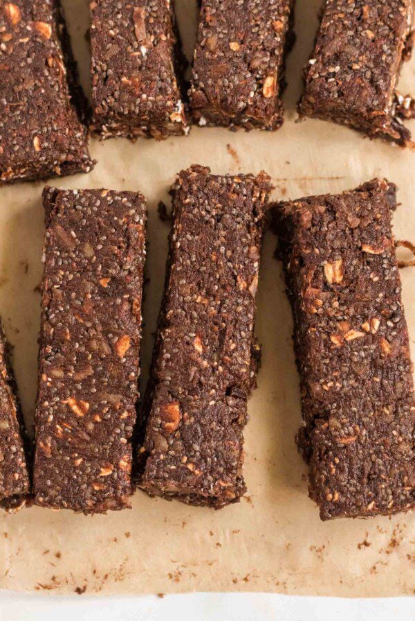 Close up of 3 chocolate energy bars on parchment paper.