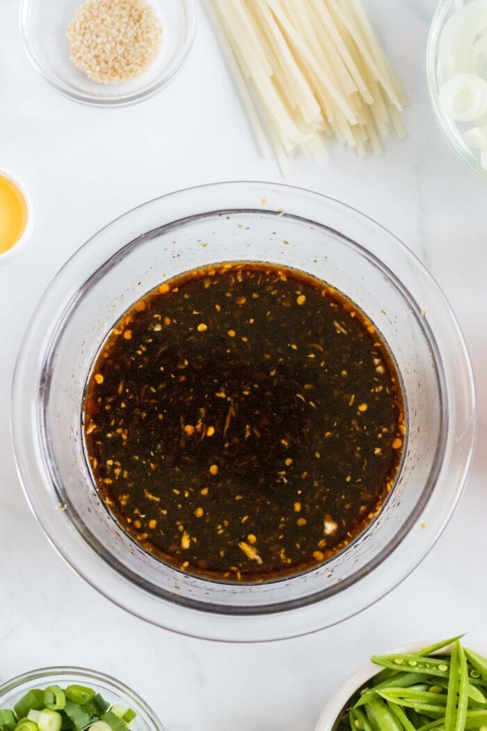 Batir la salsa lo mein en un tazón de vidrio pequeño.