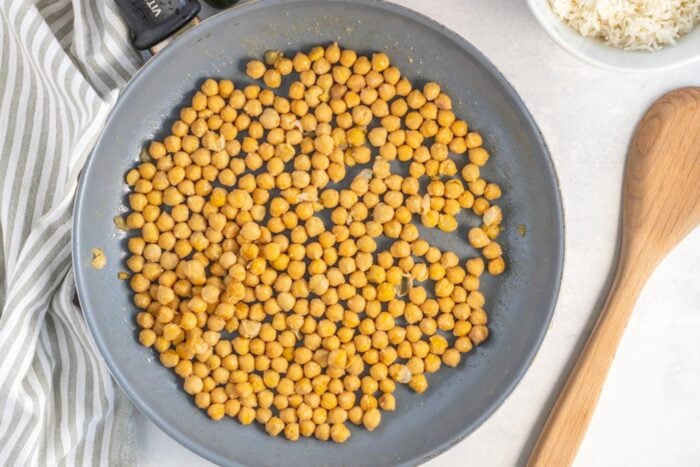 Chickpeas cooking in a skillet.