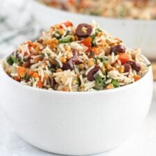 Bowl of rice and lentils with spinach and olives.