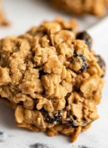Close up of an oatmeal cookie with cranberries and walnuts in it.