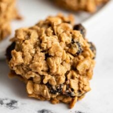 Close up of an oatmeal cookie with cranberries and walnuts in it.