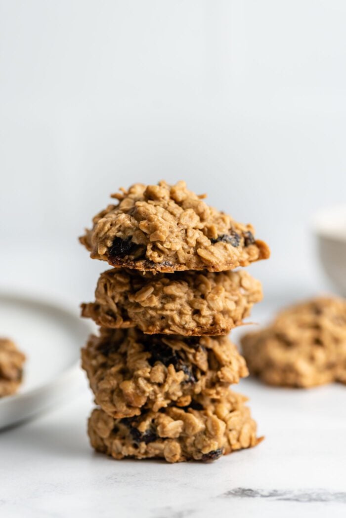 Stack of 4 oatmeal cookies with cranberries and walnuts in them.
