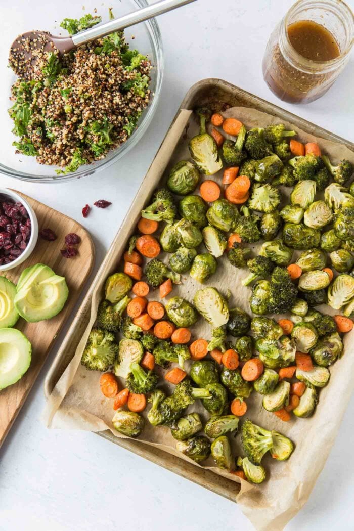 Roasted brussels sprouts, carrots and broccoli on a baking sheet.