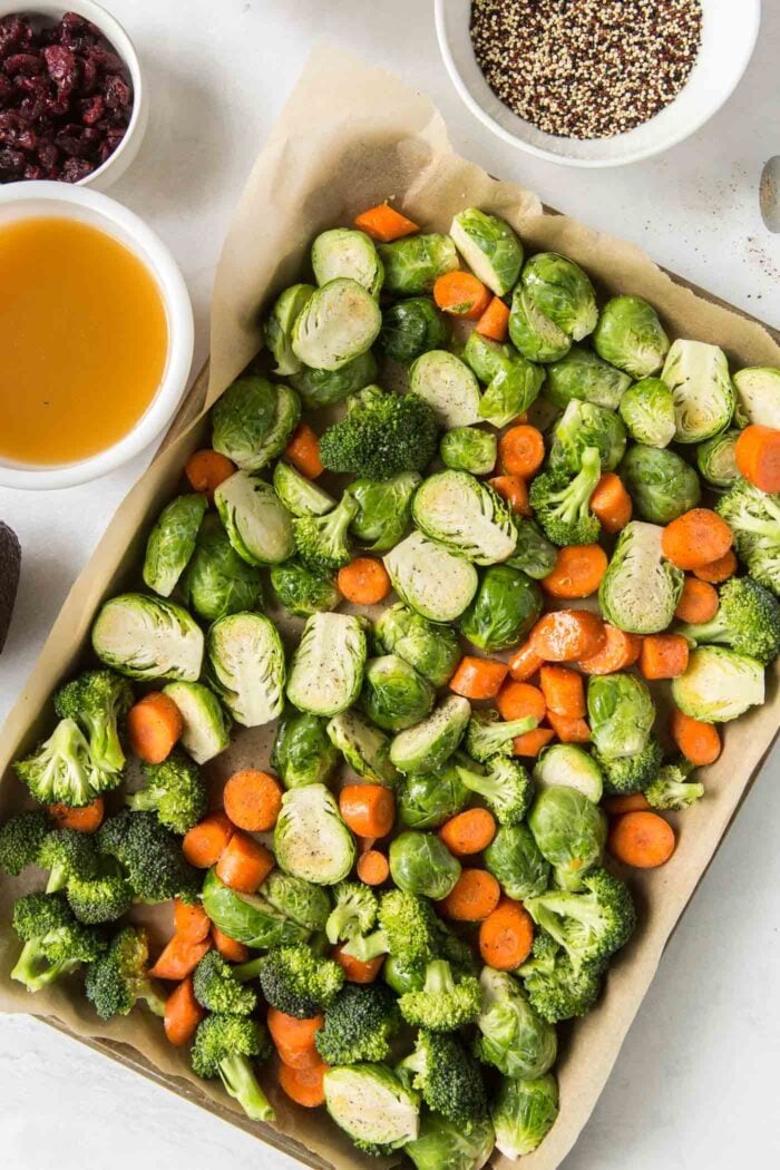 Chopped carrots, brussels sprouts and broccoli on a baking pan.