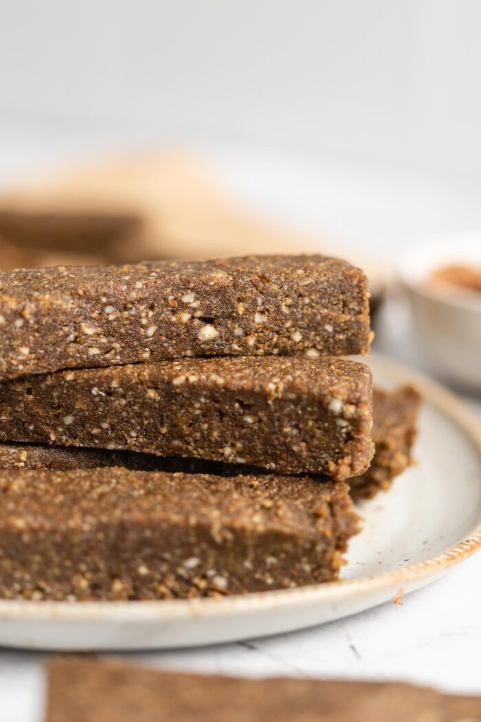Close up of no-bake vegan hemp protein bars stacked on a plate.