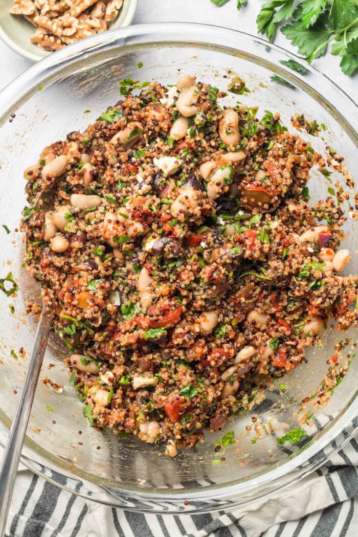 Mediterranean quinoa with white beans and vegetables ready to be added to stuffed peppers.