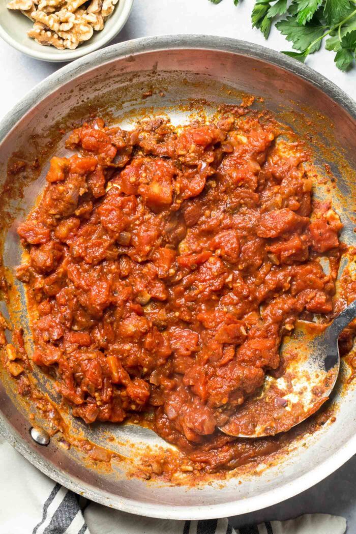 Tomato paste, tomato sauce, onion and garlic cooking in a hot skillet.