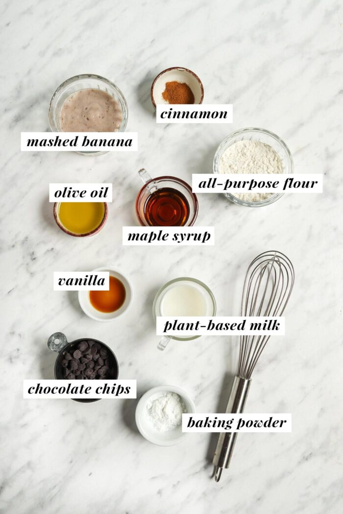 All the ingredients needed for making a vegan banana bread mug cake. Each ingredient is labelled with text.