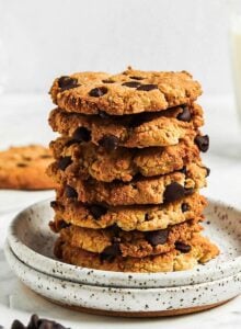 Stack of almond flour chocolate chip cookies on a small plate with a glass of milk in the background.