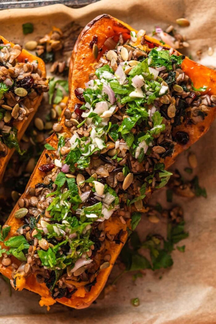 Stuffed butternut squash filled with a rice and lentil filling topped with salsa verde.
