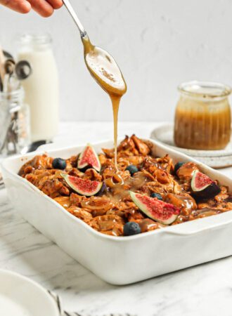 Drizzling caramel sauce over a casserole dish of baked vegan French toast.