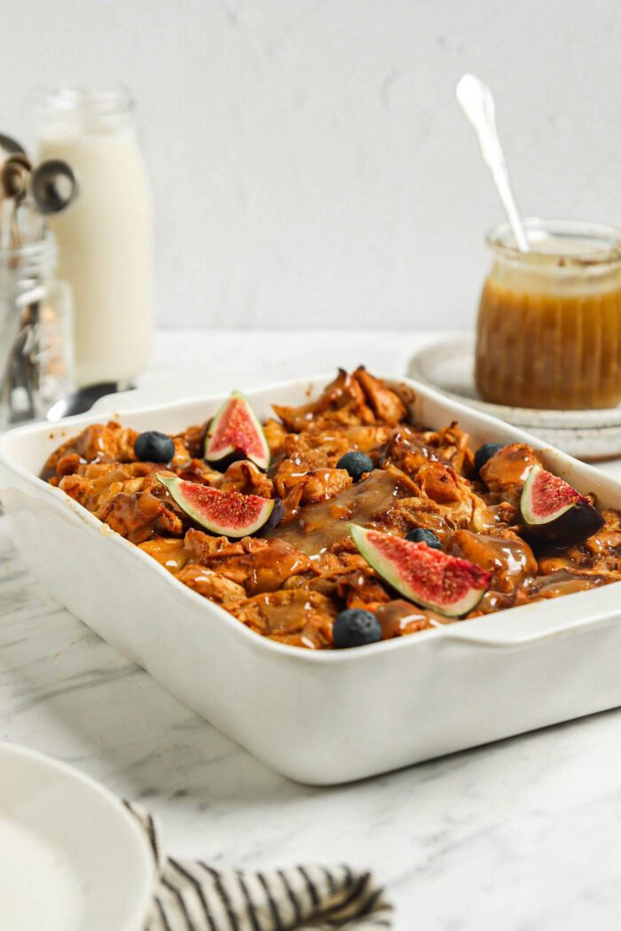 Baked french toast casserole topped with sliced figs and caramel sauce.