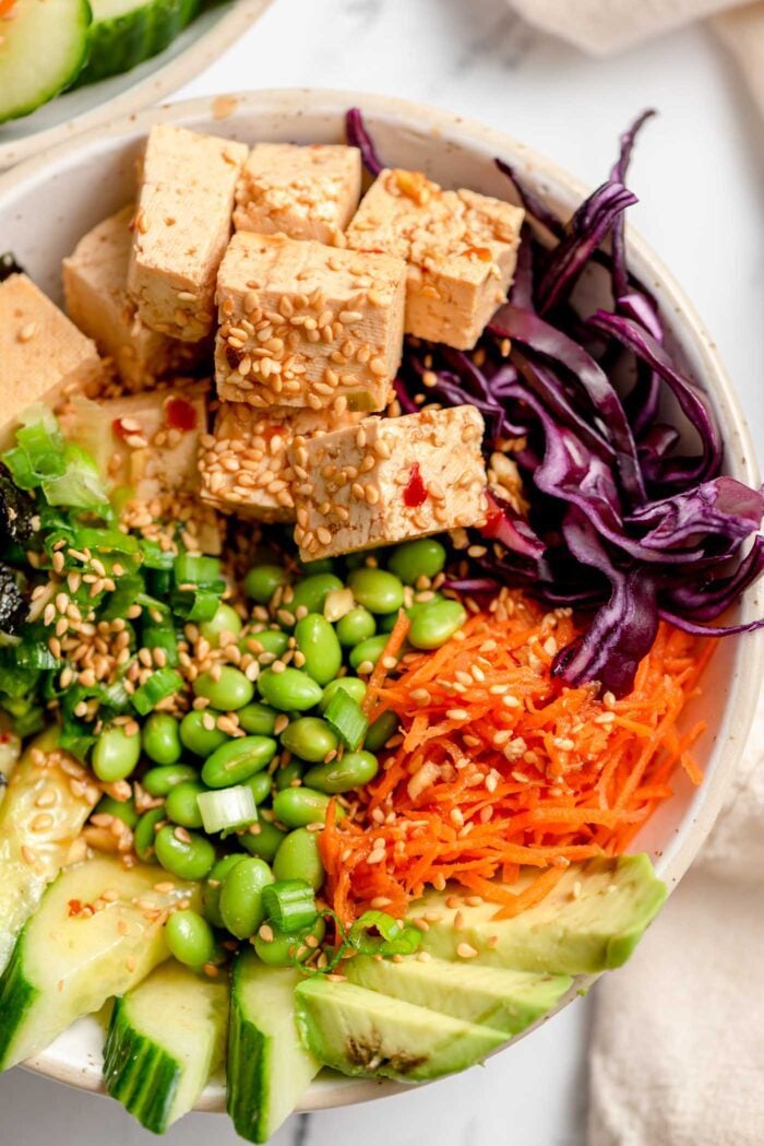 Close up overhead view of a vegan poke bowl with veggies, edamame and tofu poke.