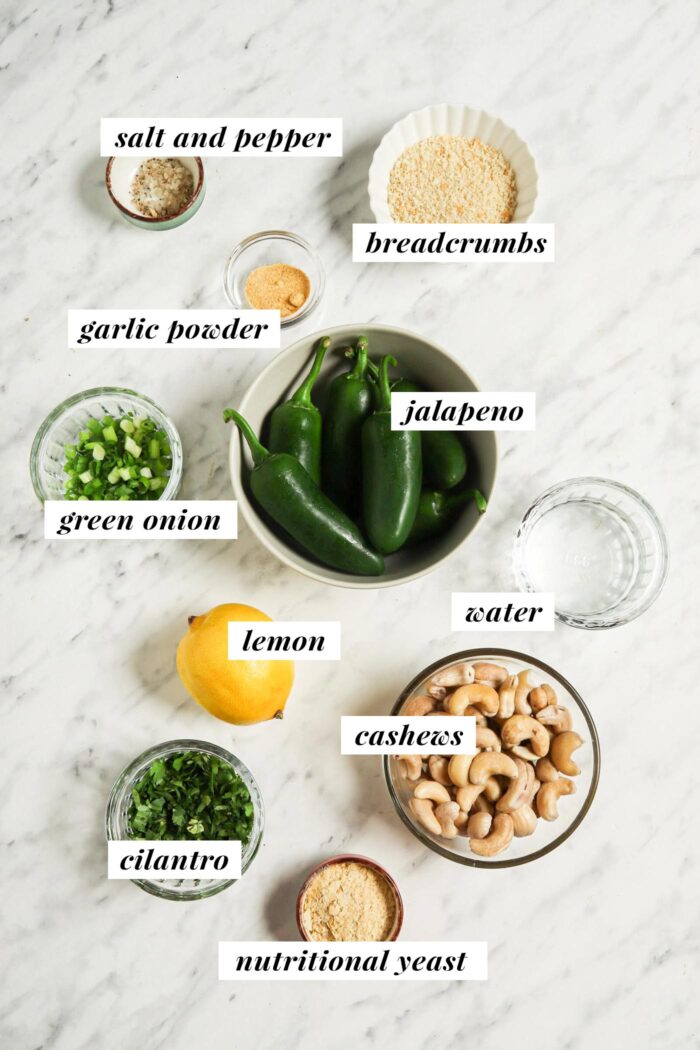 Todos los ingredientes necesarios para hacer una receta de popper de jalapeño vegano al horno.  Cada ingrediente está etiquetado con texto.