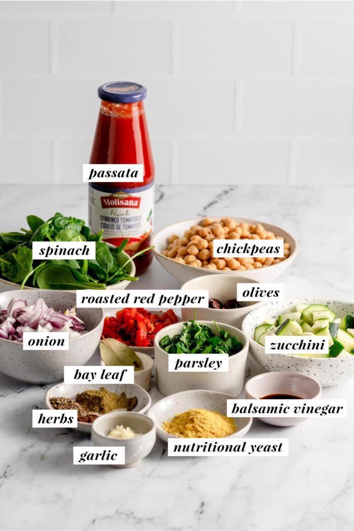 Todos los ingredientes para una receta de sartén mediterránea de garbanzos.  Cada ingrediente está etiquetado con texto y consulte la tarjeta de recetas en esta página para ver la lista.