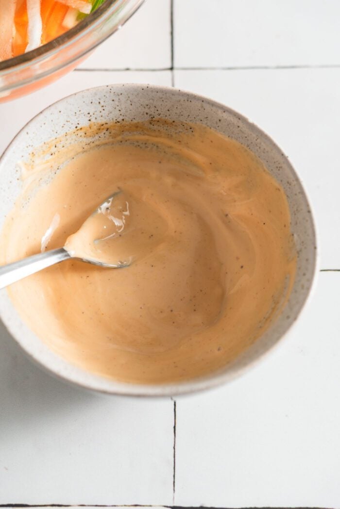 Homemade spicy mayonnaise in a small bowl with a spoon.
