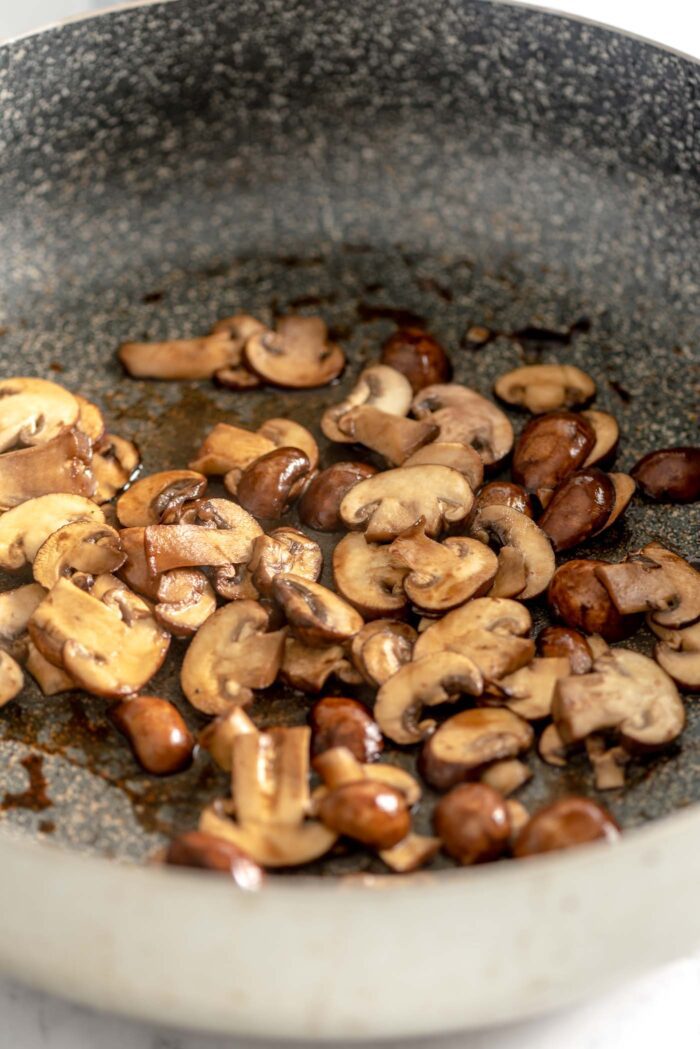 Chopped mushrooms cooking in a saucepan.