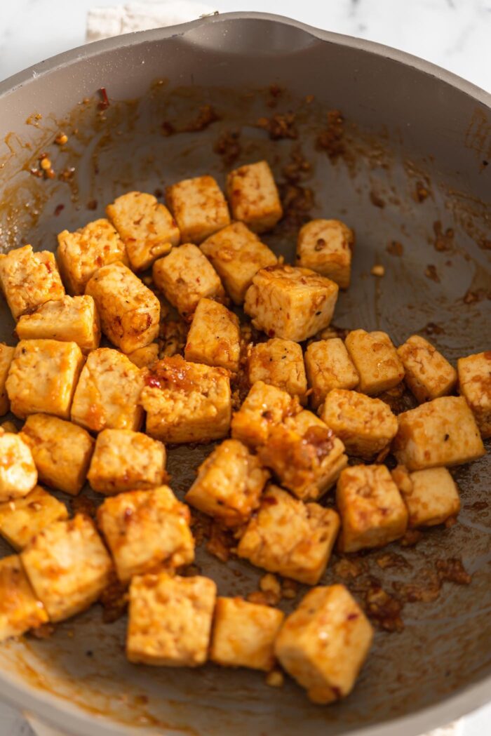 Crispy sweet chili cubes cooking in a skillet.