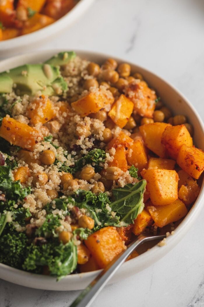 Close up of a quinoa power bowl with squash, kale and avocado.