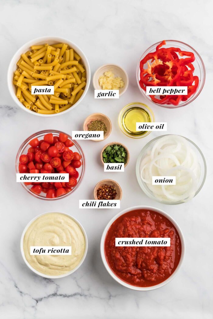 The ingredients needed for making a vegan baked ziti recipe. Each ingredient is labelled with text.