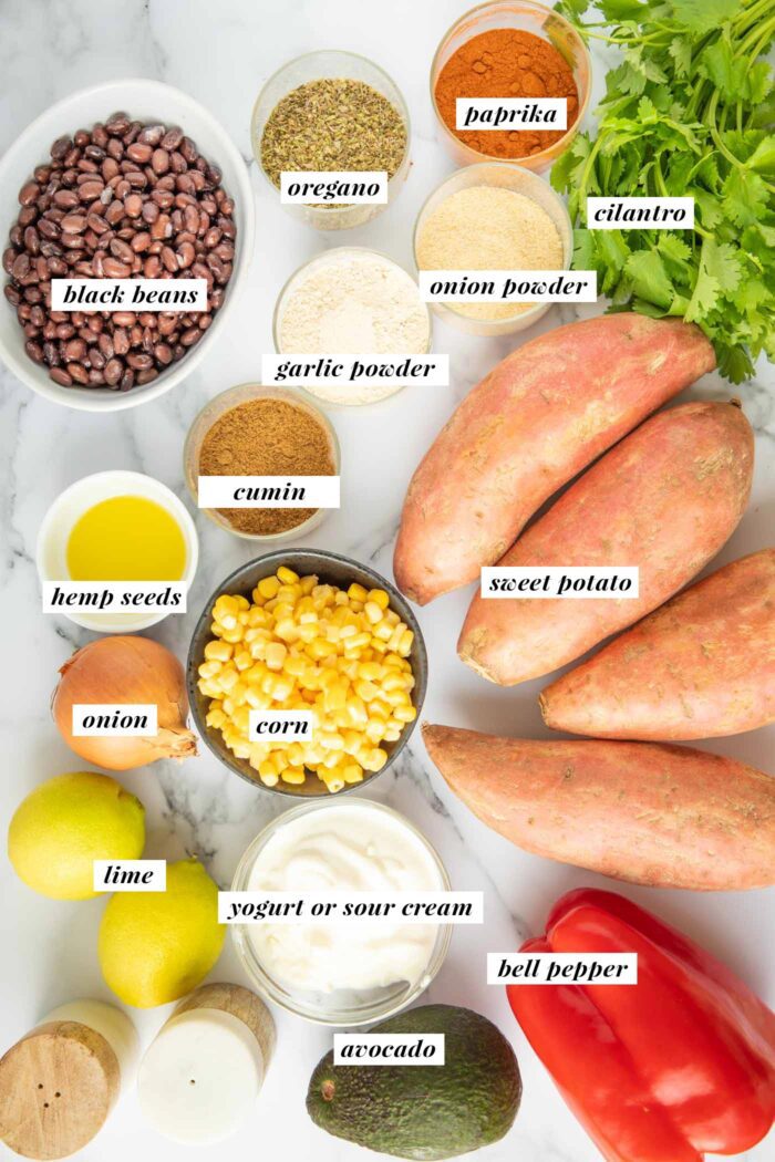 All the ingredients gathered for making a black bean and corn stuffed sweet potato topped with sour cream and avocado.