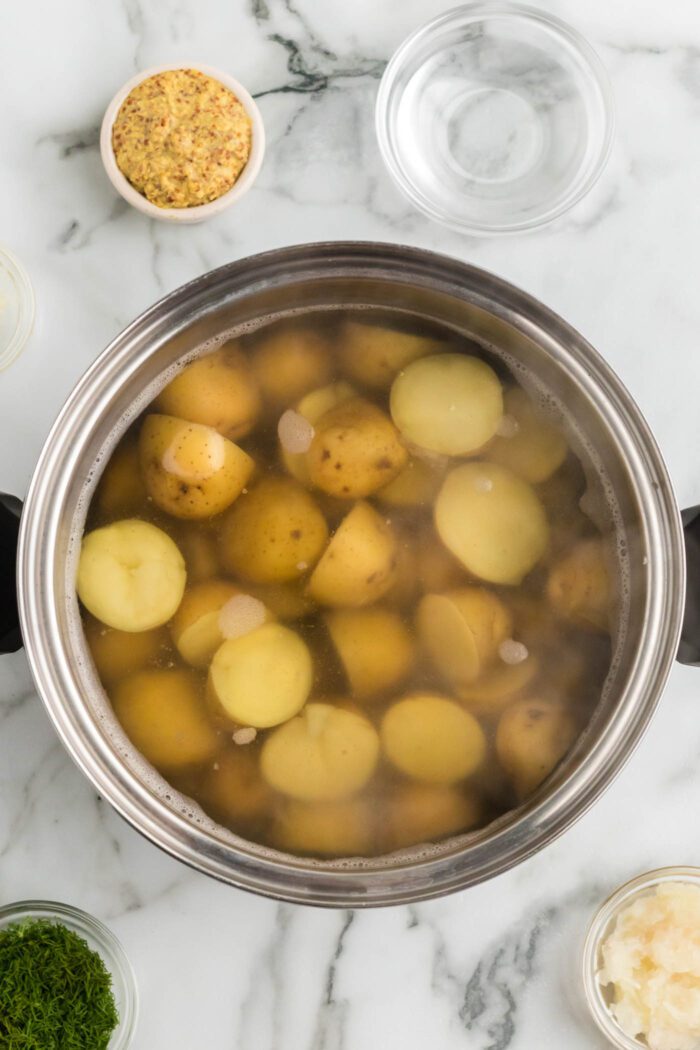Cooked boiled potatoes in a large saucepan of water.