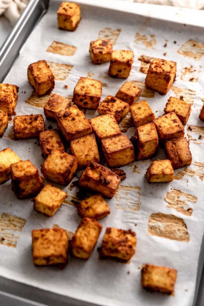 Cubes of spicy baked tofu on a baking pan.