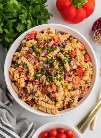 Overhead view of a large bowl of vegan southwest pasta salad with cilantro, black beans, corn, bell pepper and chipotle dressing..