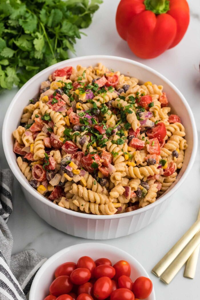 Overhead view of a large bowl of vegan southwest pasta salad with cilantro, black beans, corn, bell pepper and chipotle dressing..