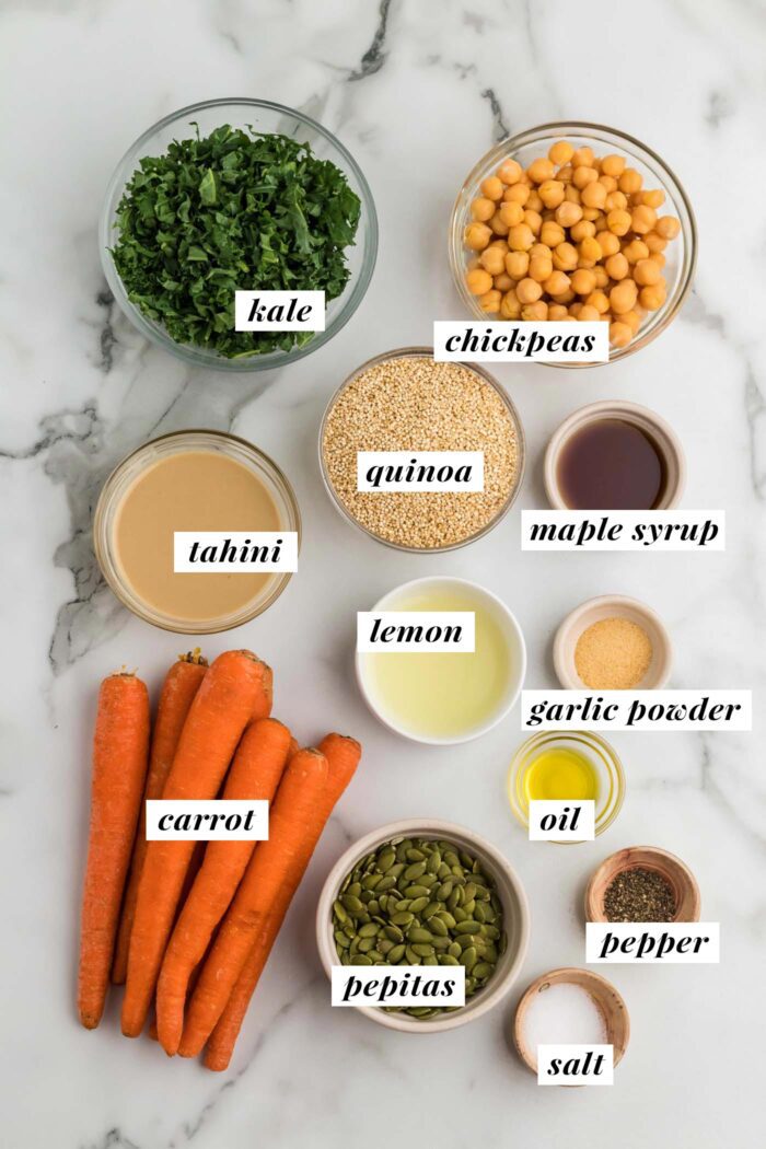 Ingredients for a kale, quinoa, chickpea and carrot salad with tahini sauce. Each ingredient is labelled with text.
