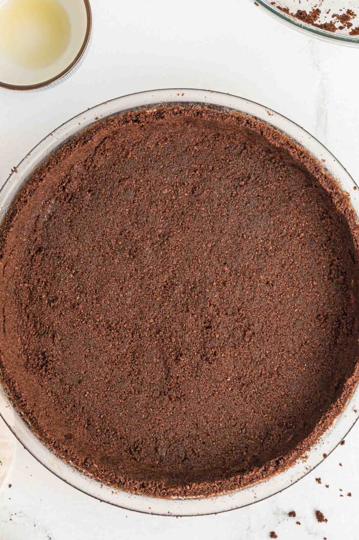 A chocolate graham cracker pie crust firmly pressed into a round 9-inch glass pie dish.