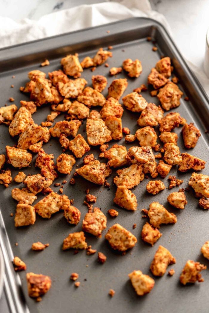 Crispy spiced tofu pieces on a baking tray.