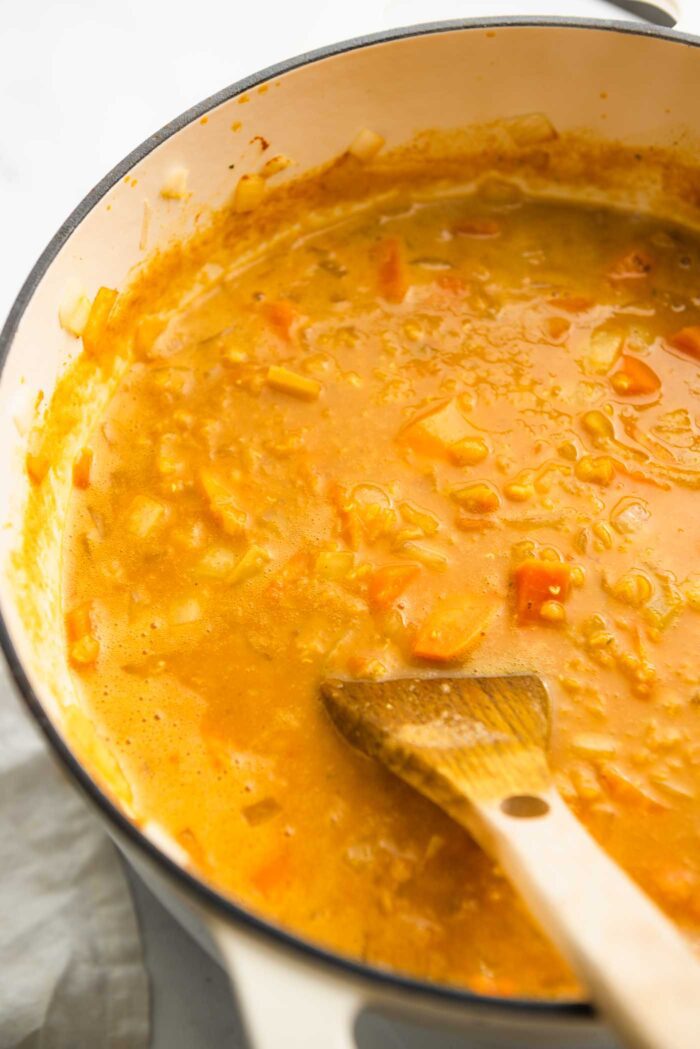 Tejszínes édesburgonya vöröslencse leves főzés egy nagy fazékban.