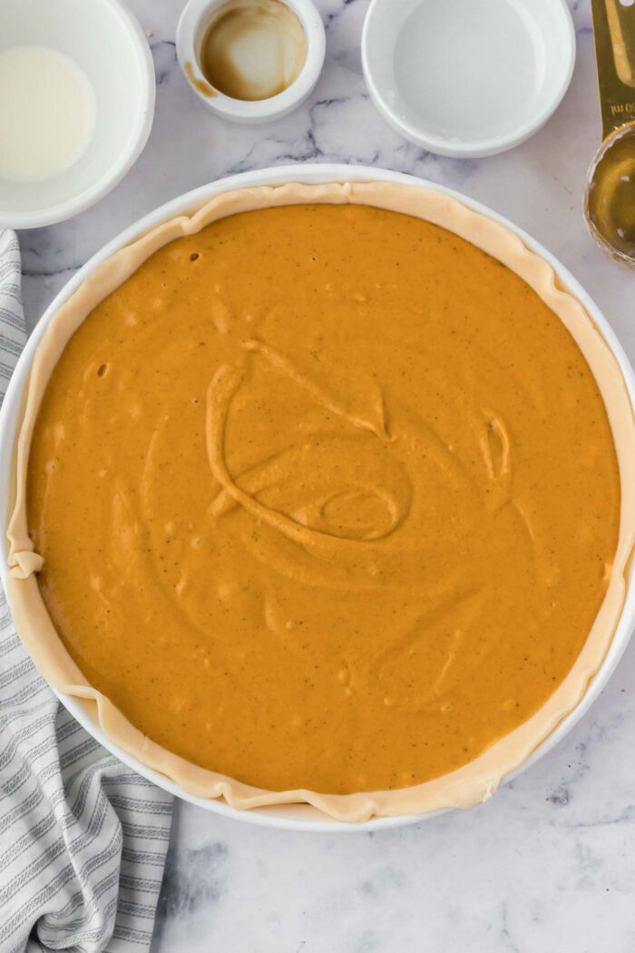 Unbaked sweet potato pie in a pie dish ready to go in the oven.