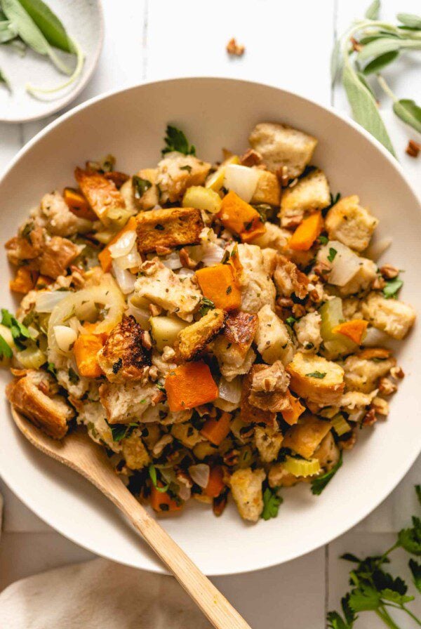 A bowl of butternut squash stuffing with bread, celery, apple and herbs.